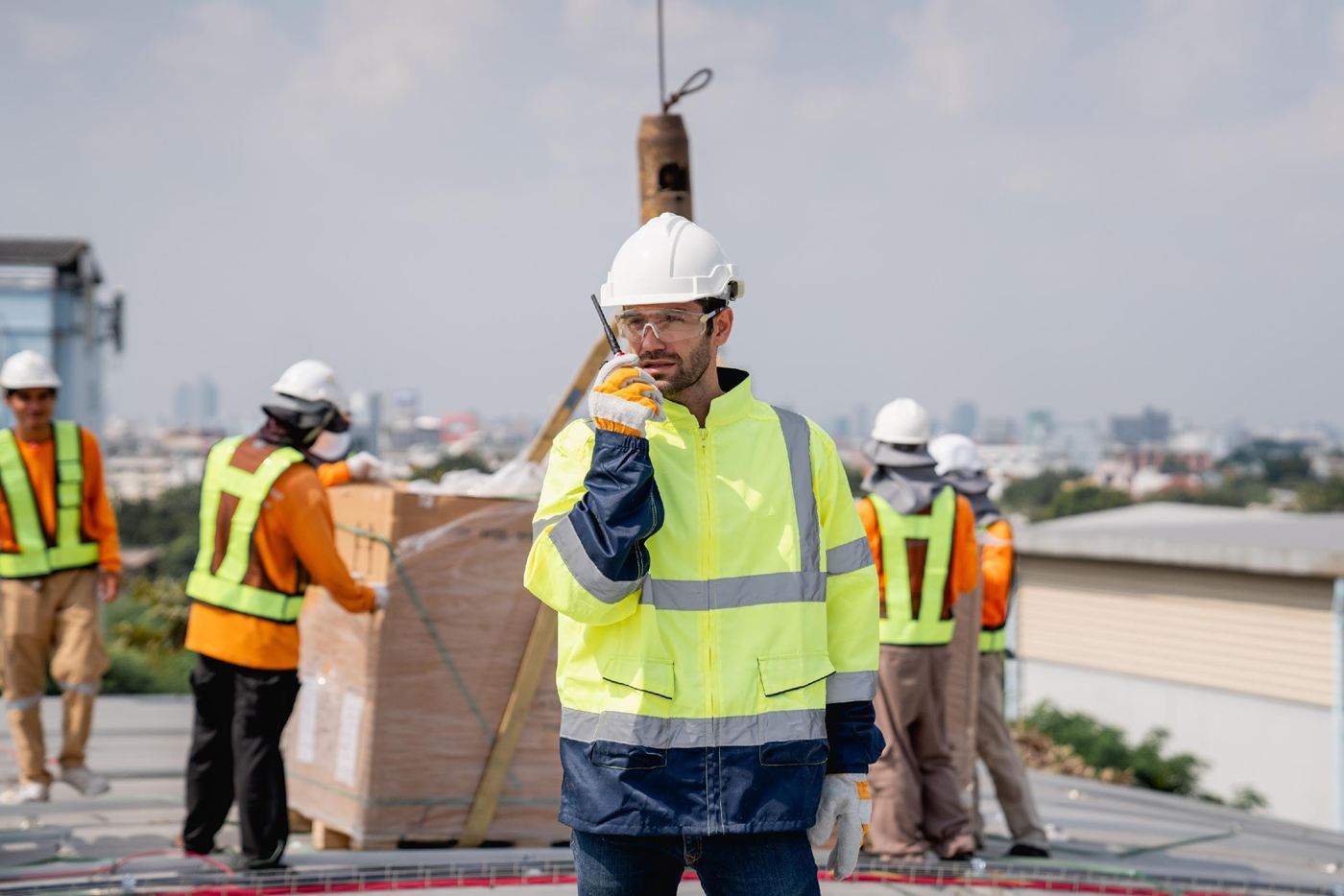Site engineer in a hard hat coordinating work on a rooftop