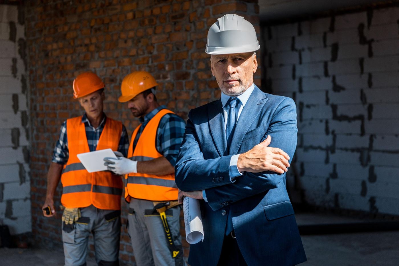 Developer in a suit with construction workers on site