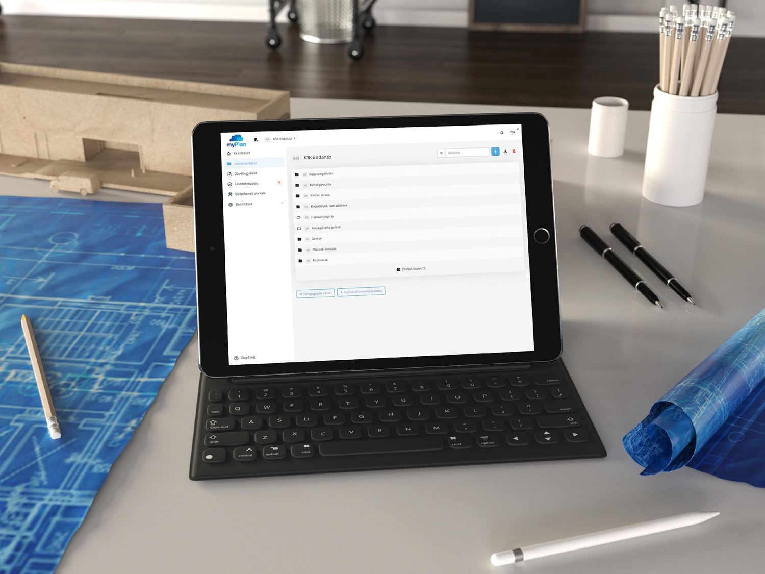 myPlan.cloud on a tablet next to construction blueprints